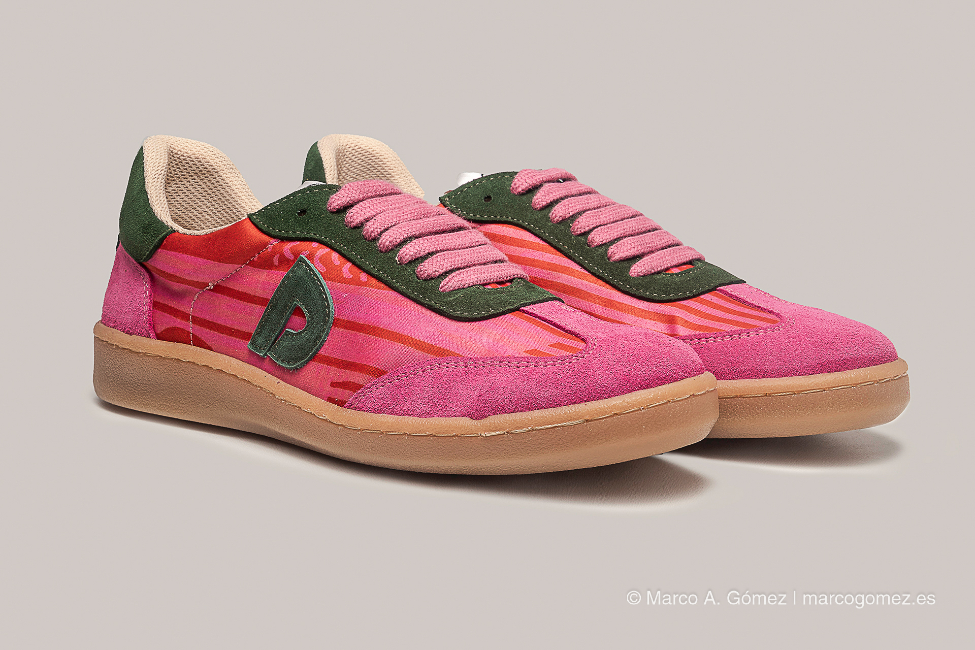 Proyecto integral Zapatillas casuales de la línea Dakart en vibrantes tonos fucsia y rojo, combinadas con detalles en ante verde oscuro y cordones rosados.