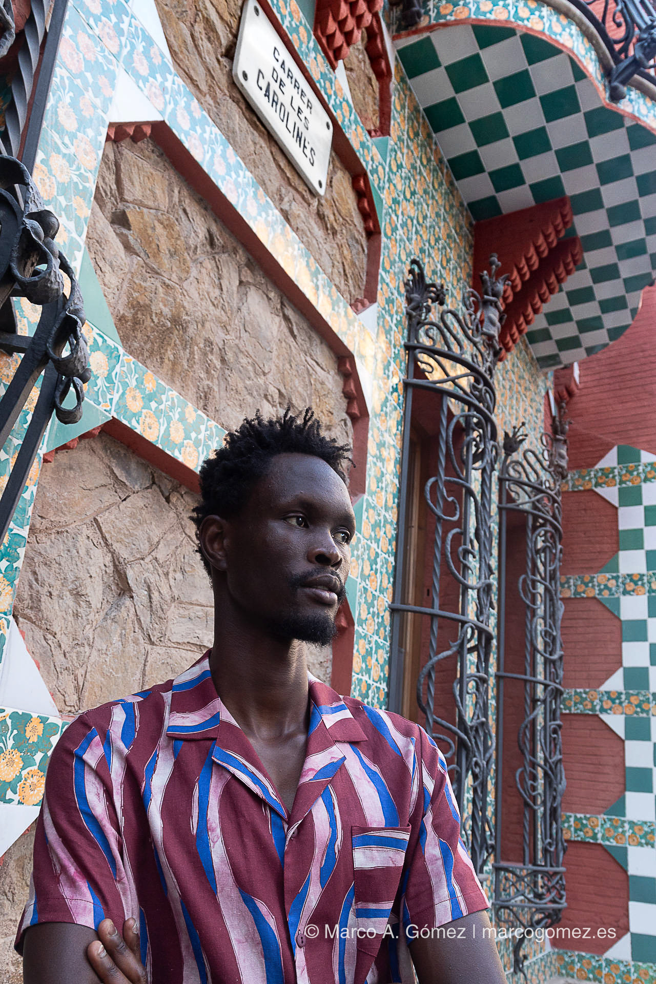 Proyecto integral Modelo con camisa estampada posando frente a la fachada arquitectónica modernista de la Casa Vicens en Barcelona para el proyecto Dakart.